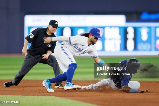 Bo Bichette of the Toronto Blue Jays tags Taylor Trammell of the Seattle Mariners as he's caught stealing second base in the fourth inning of their...