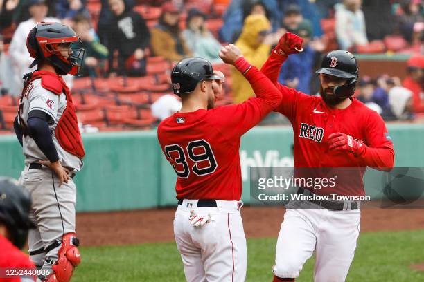 As catcher Cam Gallagher of the Cleveland Guardians looks on, Connor Wong of the Boston Red Sox is congratulated by Christian Arroyo after his...