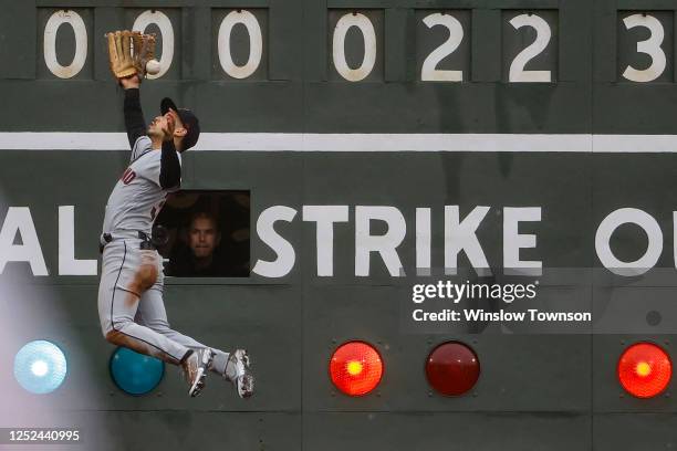 Steven Kwan of the Cleveland Guardians leaps but can't make the catch on a double by Enmanuel Valdez of the Boston Red Sox during the eighth inning...