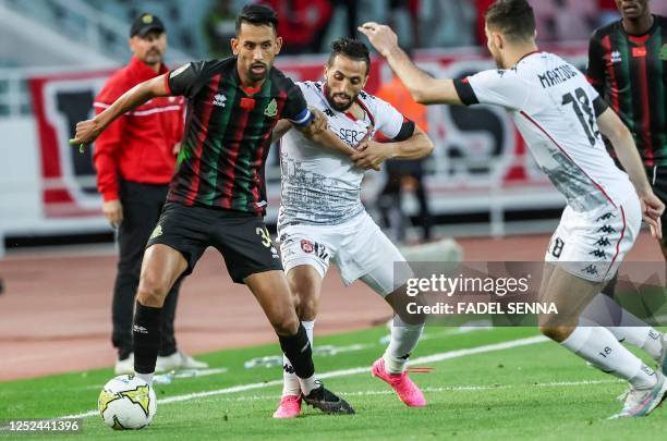 S defender Mohamed Rabie Hrimat vies for the ball with USM Alger's forward Meziane Bentahar during the CAF Confederation Cup quarter-final football...