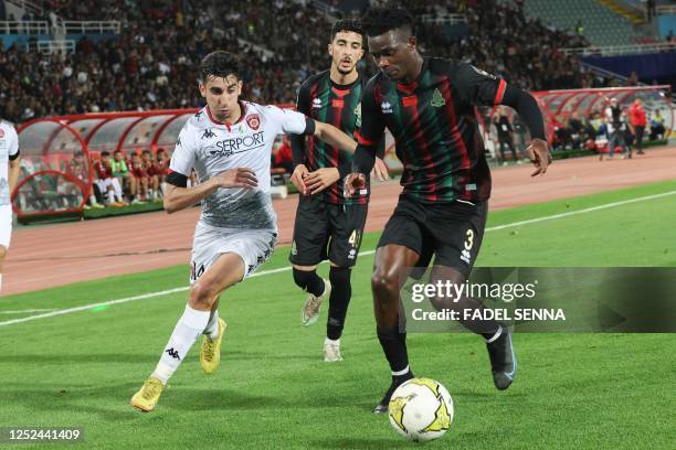 S defender Emmanuel Imanishimwe vies for the ball with USM Alger's midfielder Brahim Benzaza during the CAF Confederation Cup quarter-final football...