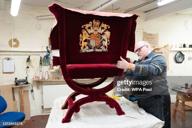 In this photo released on April 30, 2023 - Upholsterer Alex Burnett works on one of the throne chairs which will be used for the coronation of King...