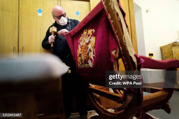 In this photo released on April 30, 2023 - Upholsterer Alex Burnett works on restoring a throne chair at the Marlborough House workshops in the lead...