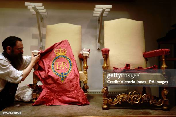 Upholsterer works on restoring a throne chair at the Marlborough House workshops at Marlborough House, London, in the lead up to the coronation of...