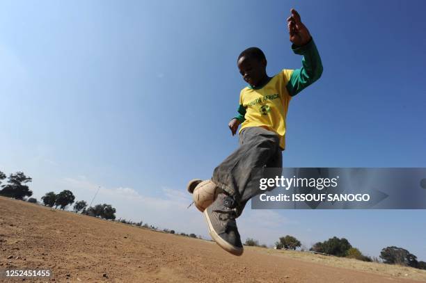 Boy plays football near George Thabe Stadium on June 13, 2010 in Sharpeville. The 2010 World Cup continues through July 11 in South Africa. AFP PHOTO...