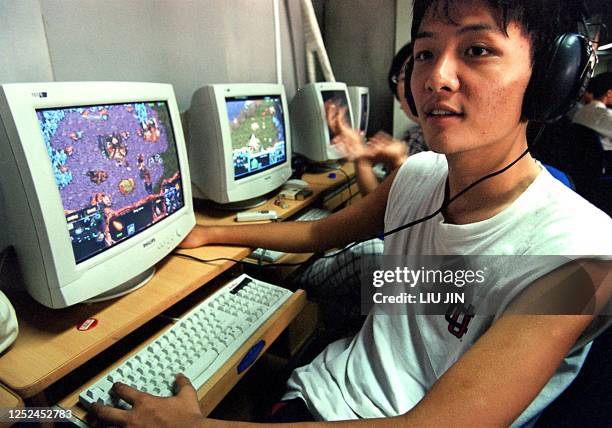 Chinese student enjoys playing a computer game spending the remainder of his vacation at a game bar in Shanghai, 20 August 2000. For most students in...