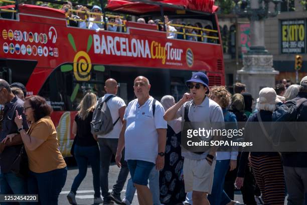 Tourists are seen on a tourist bus traveling through the city center. Barcelona has received large crowds of tourists visiting landmark buildings and...