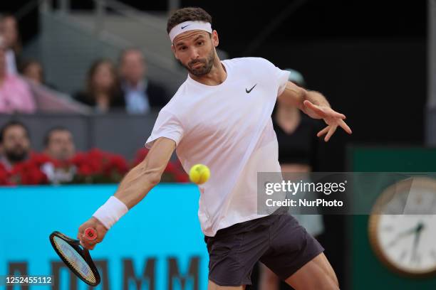 Grigor Dimitrov of Bulgaria plays against Carlos Alcaraz of Spain during their third round match on day seven of the Mutua Madrid Open at La Caja...