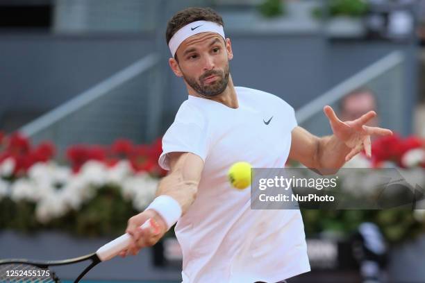 Grigor Dimitrov of Bulgaria plays against Carlos Alcaraz of Spain during their third round match on day seven of the Mutua Madrid Open at La Caja...