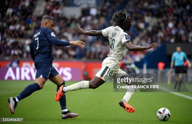 Paris Saint-Germain's French forward Kylian Mbappe fights for the ball with Lorient's midfielder Maxime Wackers during the French L1 football match...