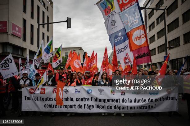 Protesters carry union flags as they march behind a banner while taking part in a demonstration on May Day , to mark the international day of...