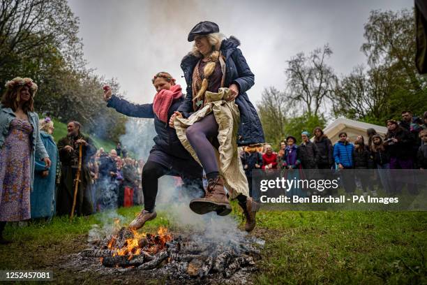 People jump the Beltane bonfire at Chalice Well, Glastonbury, Somerset, where Beltane is celebrated at sunrise and throughout the day. Picture date:...