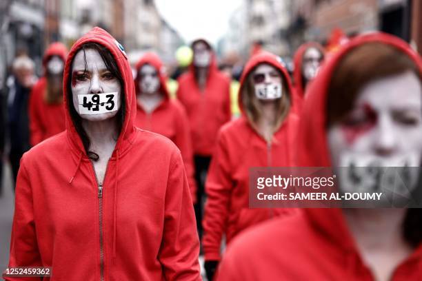 Protestors dressed as "Marianne" take part in a demonstration on May Day , to mark the international day of the workers, more than a month after the...