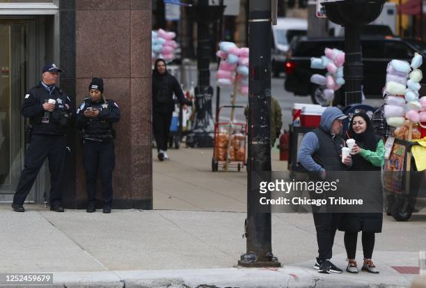 Chicago police officers stand at the corner of Washington Street and Michigan Avenue on April 23, 2023.