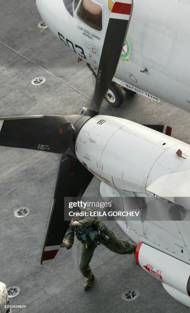 Navy E-2C Hawkeye pilot checks one of the propellers of the aircraft ...