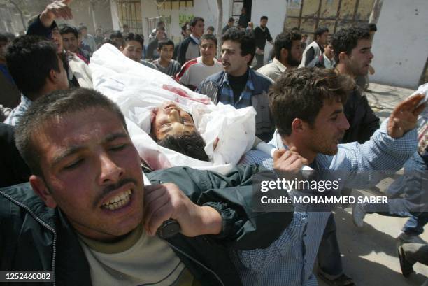 Palestinian carry the body of thirteen-year-old Thaer Rihan during his funeral through the Jabalia refugee camp, north of Gaza City 06 March 2003....