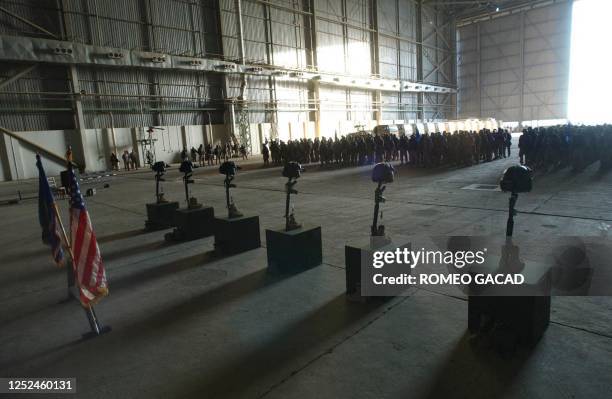 Members of the Aviation Brigade pay tribute to six killed comrades, represented by six pairs of boots, M-16 rifles, helmets and night vision goggles,...