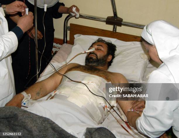 An injured Iraqi man receives treatment at the al-Kark hospital in Baghdad 22 March 2003. Iraqi Information Minister Mohammad Said al-Sahhaf said...