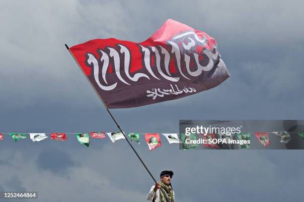 Young man is seen waving a flag with the inscription, "There is no god but Allah." during the event. The birth of the Islamic Prophet Muhammad was...