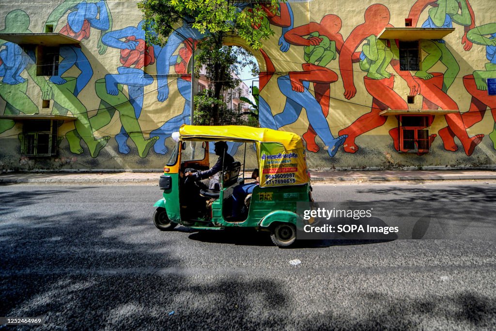 Auto Rickshaw Ride An auto rickshaw rides past a mural in the open air gallery at Lodhi ...