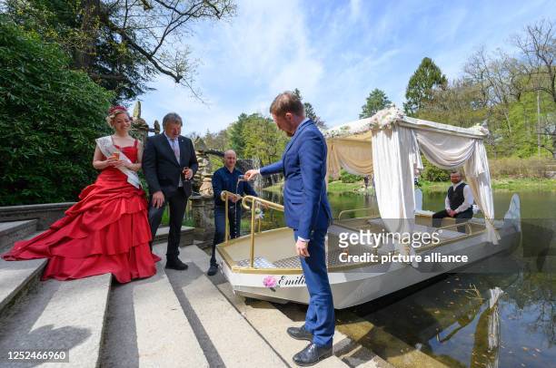 May 2023, Saxony, Gablenz: Michael Kretschmer , Prime Minister of Saxony, christens a wedding barge named "Emilie" at the Rakotz Bridge in the...