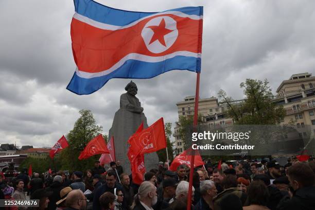 Man holds the flag of North Korea as others hold Soviet flags during the rally of Russian Communist Party marking the Labour Day on May 1, 2023 in...