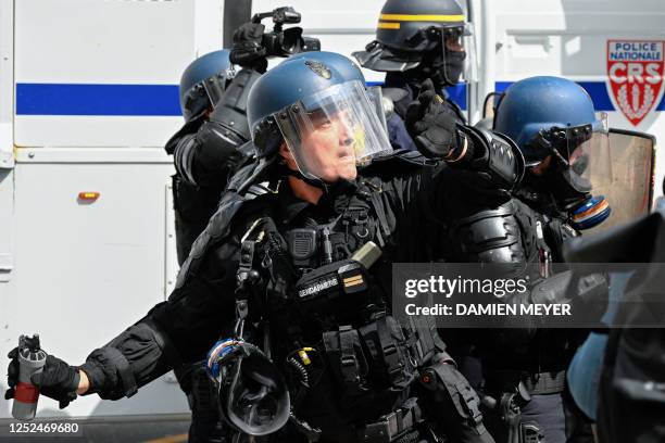 French Riot Policeman throws a tear gas grenade towards protesters during a demonstration on May Day to mark the international day of the workers,...