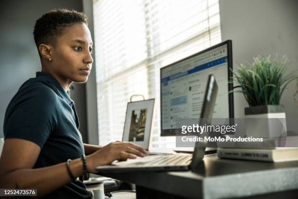 young woman working on desktop computer at home - lavoro a domicilio foto e immagini stock