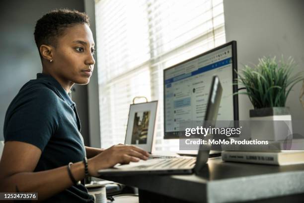 young woman working on desktop computer at home - pc woman stockfoto's en -beelden