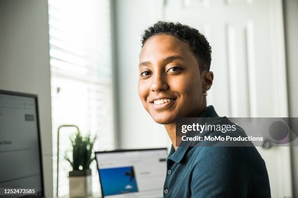 young woman working on desktop computer at home - polo shirt stock pictures, royalty-free photos & images