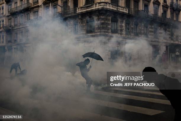 Protesters walk in teargas as they take part in a demonstration on May Day to mark the international day of the workers, more than a month after the...