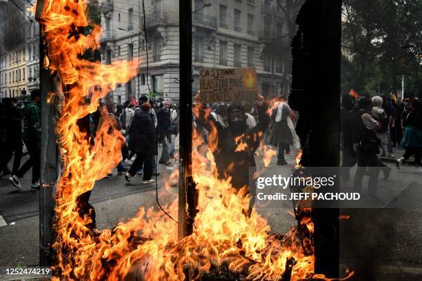 Protestor holds a sign reading "Shoked by burnt plastic but not by our stolen pensions" during a demonstration on May Day to mark the international...