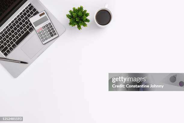 laptop and calculator on white desk overhead view - calculator top view stock-fotos und bilder