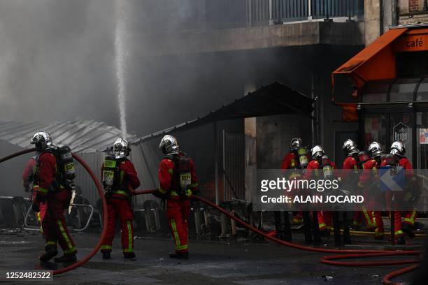French firefighters work to extinguish a fire during a demonstration on May Day to mark the international day of the workers, more than a month after...