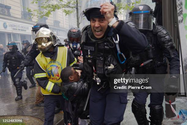 An injured police officer is evacuated amid clashes during a protest march on May 1, 2023 in Paris, France. This year's May Day protests coincide...