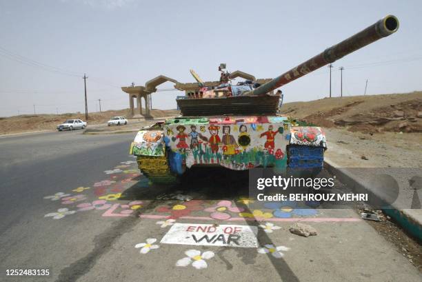 Damaged Iraqi T-72 tank is painted by children with an "End of war" message at the eastern entrance of Iraq's oil-rich city of Kirkuk 19 May 2003....