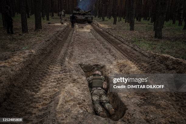 Ukrainian serviceman lies in a trench during a military exercise in the Kharkiv region on May 1 amid the Russian invasion of Ukraine.