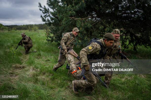 Ukrainian servicemen take part in battlefield first aid training during a military exercise in the Kharkiv region on May 1 amid the Russian invasion...