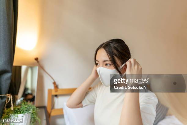asian woman taking off the mask - cloth face mask stock pictures, royalty-free photos & images