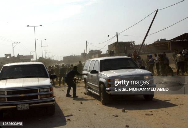 Angry Palestinians throw stones at US vehicles at the site where a convoy carrying US diplomats was hit by a road-side bomb killing at least three of...