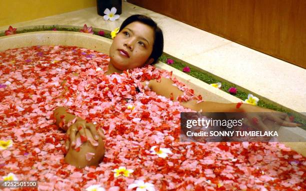 Balinese woman takes a "flower bath" at a traditional spa centre in Nusa Dua on the Indonesian resort island of Bali, 24 April 2007. Various...