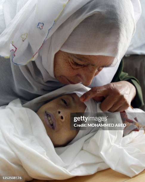 The aunt of 10-year-old Sana al-Daur gives her a farewell kiss at the start of her funeral 02 September 2003 in Jabalia refugee camp, north of Gaza...