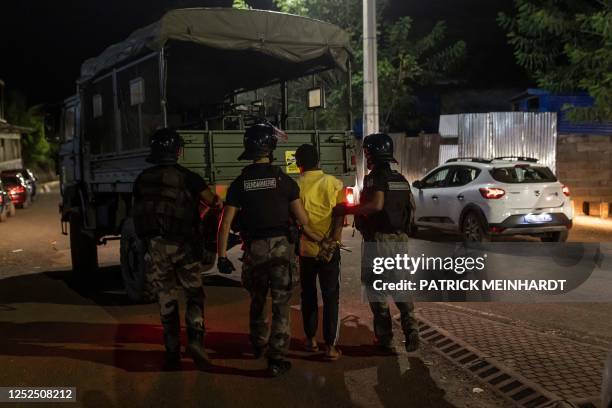 French gendarmes arrest a man during a security operation in Dzoumogne, on the French Ocean island of Mayotte, on May 1, 2023.