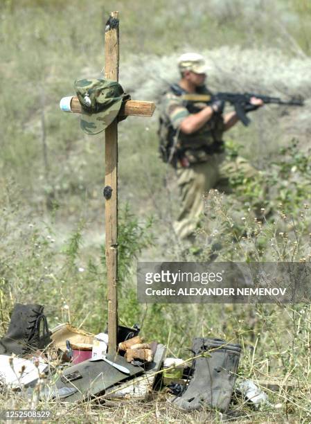 Russian soldier controls 27 August 2003 an area outside Grozny behind a cross made to commemorate the place where nine Russian paratroopers were...