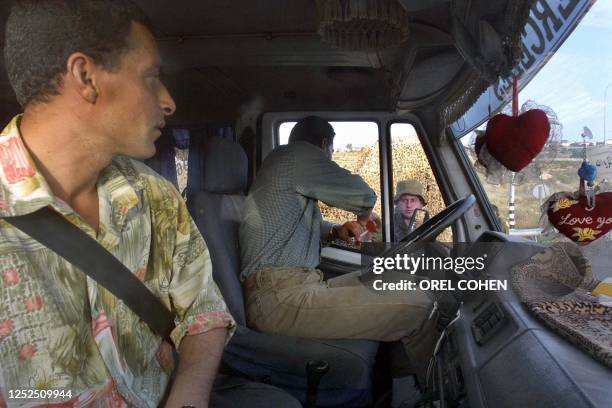 An Israeli soldier checks a Palestinian truck driver at the Tapuah junction checkpoint in the West Bank, south of Nablus 14 May 2003. Israeli Prime...