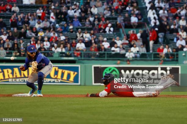 Justin Turner of the Boston Red Sox steals second base as the throw gets away from Bo Bichette of the Toronto Blue Jays during the first inning at...