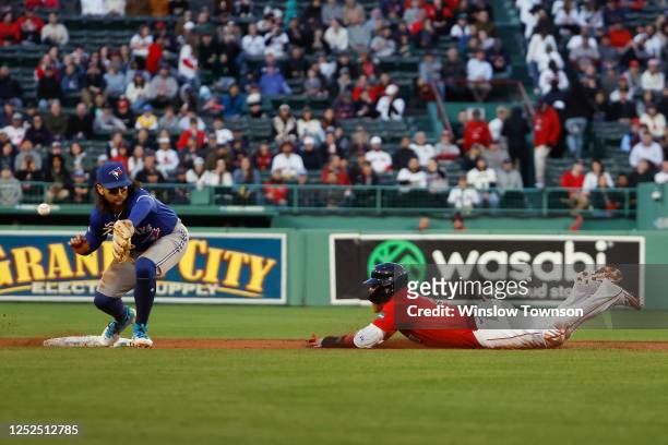 Justin Turner of the Boston Red Sox steals second base as the throw gets away from Bo Bichette of the Toronto Blue Jays during the first inning at...