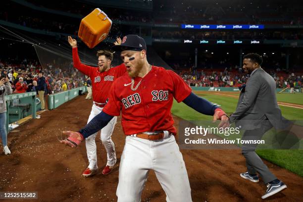 Christian Arroyo of the Boston Red Sox tosses the Gatorade bucket into the air as Alex Verdugo reacts to being doused after his walk-off home run...