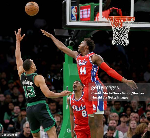 Malcolm Brogdon of the Boston Celtics shoots above the heads of De'Anthony Melton and Paul Reed of the Philadelphia 76ers during the first half of...