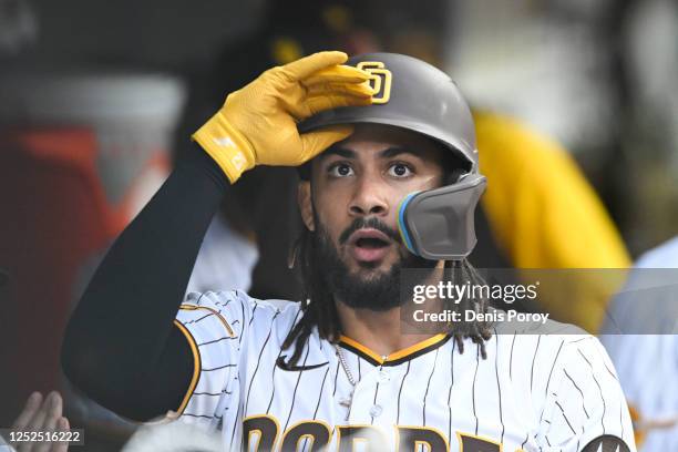 Fernando Tatis Jr. #23 of the San Diego Padres takes off his helmet in the dugout after scoring in the first inning against the Cincinnati Reds May...